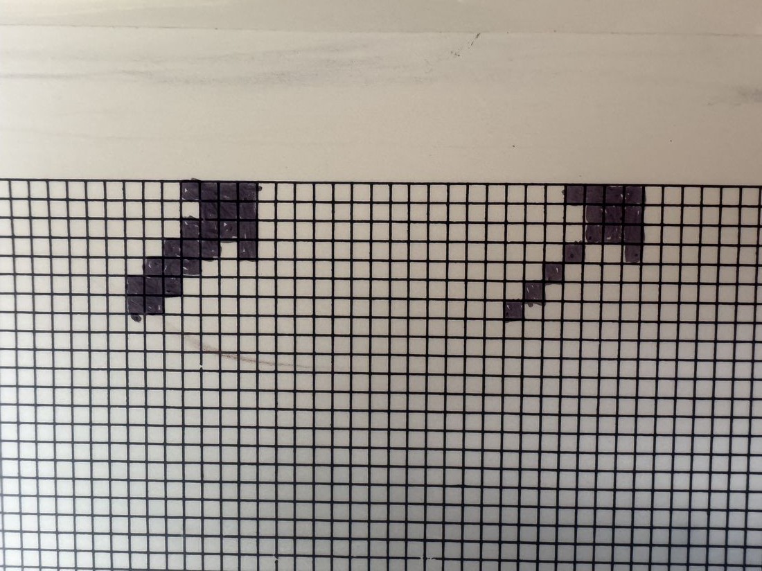The LED matrix panel lit up with a colourful pixel-art logo